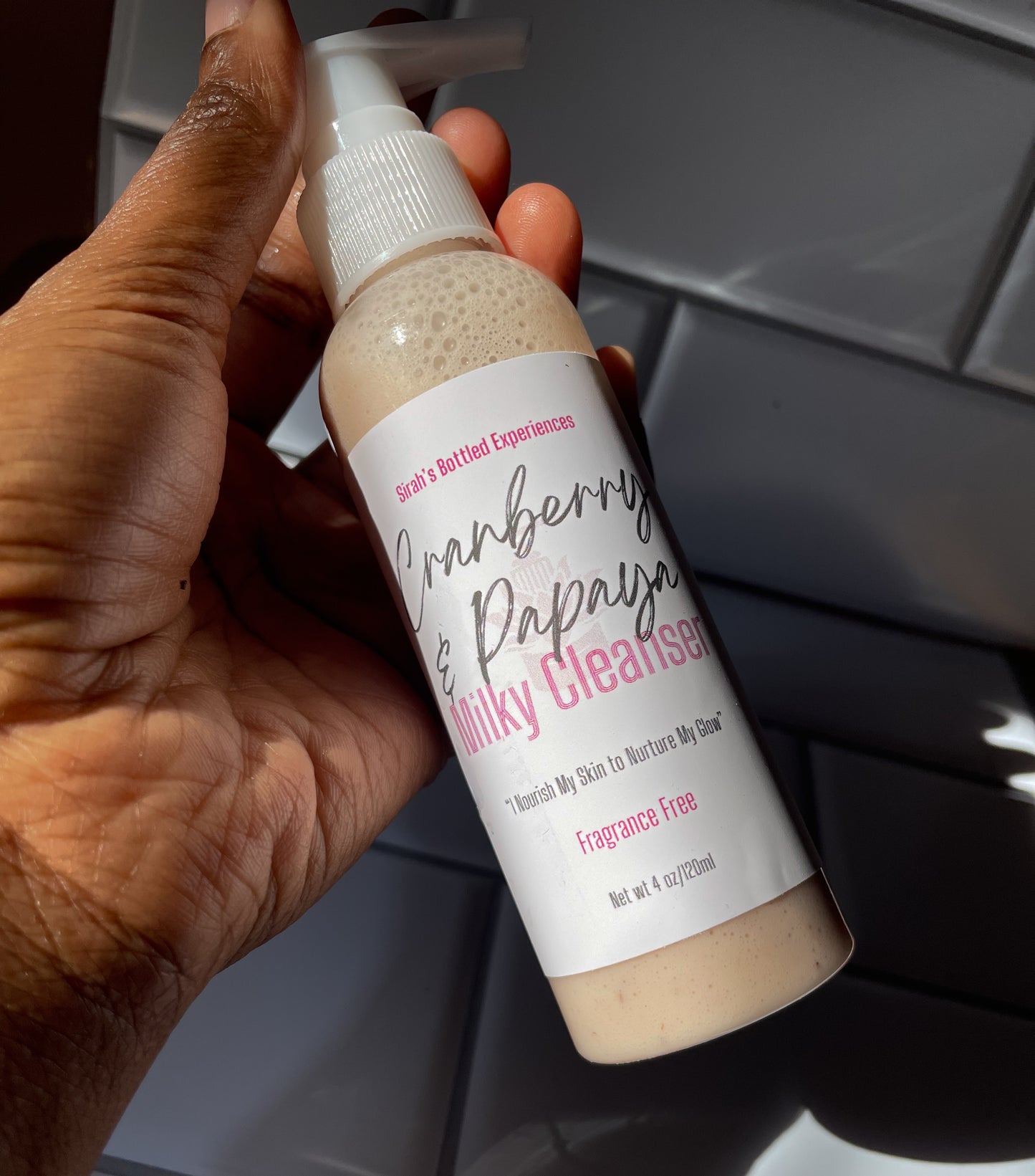 model holding Cranberry & Papaya Milky Cleanser