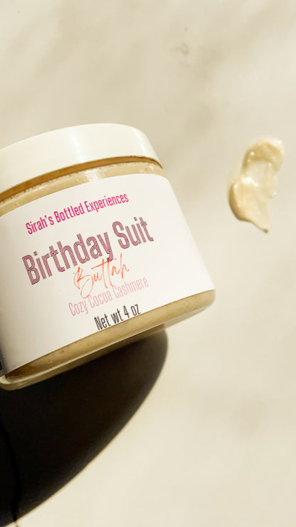Jar of 'Birthday Suit' body butter with a white label on a beige background